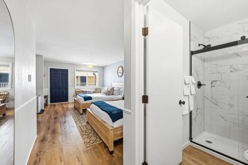 a bedroom with a bed and a bathroom with a shower at Fresh Coast Motel in Fish Creek