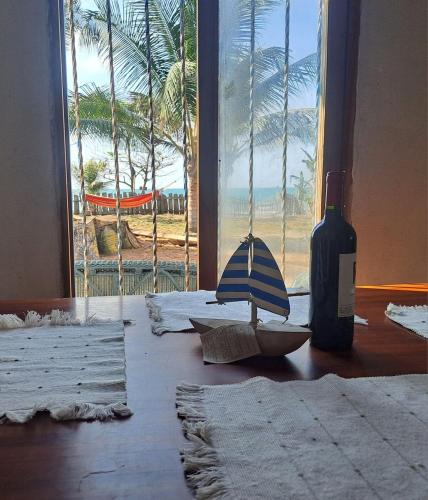 a bottle of wine and an umbrella on a table with a window at Playa VICTORIA in Arboletes