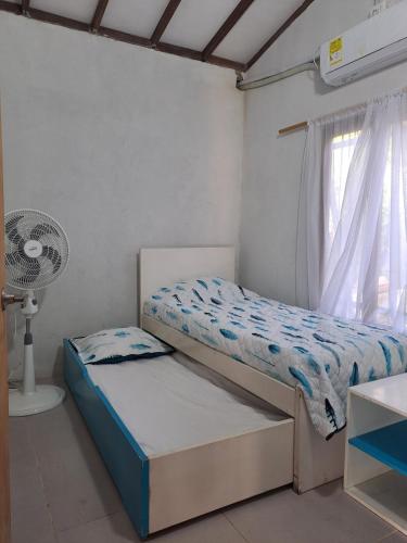 a bedroom with a bed and a fan and a window at Playa VICTORIA in Arboletes
