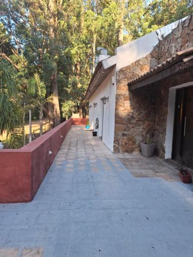 a walkway next to a stone building with trees at Kilua in Punta del Este