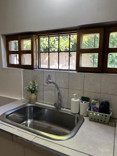 a sink in a kitchen with windows above it at Rincón Las Hiedras in Chacras de Coria