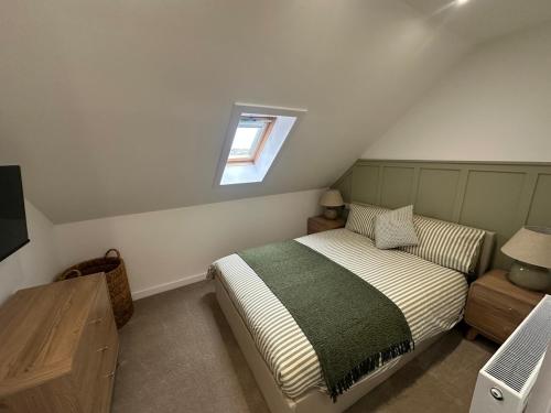 a small bedroom with a bed and a window at Modern Two- bedroomed flat in Wick, Caithness in Wick