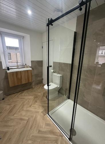 a bathroom with a glass shower and a toilet at Modern Two- bedroomed flat in Wick, Caithness in Wick