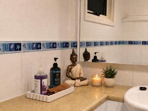 a bathroom with a statue of a buddha on a counter at Hidden Gem in the CBD in Coffs Harbour