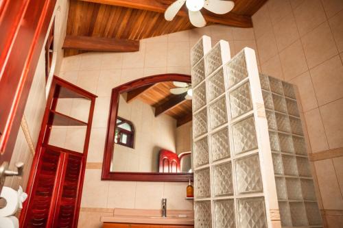 a bathroom with a mirror and a sink at Host Company Jaco Luxury in Jacó