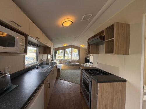 a kitchen with a sink and a stove top oven at Prime lakeside caravan at Haven Golden Sands in Mablethorpe