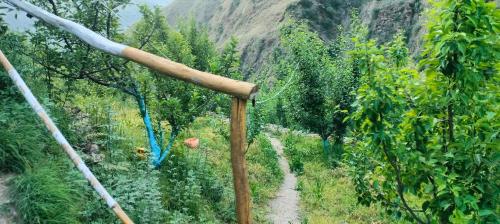 a bamboo pole in the middle of a field of trees at Ambar Cottage in Kullu Manali