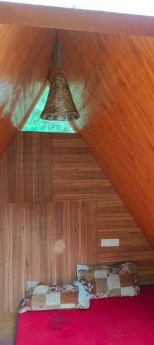 ajar view of a room with a bed and a ceiling at Ambar Cottage in Kullu Manali