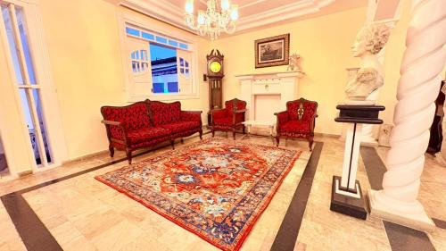 a living room with red chairs and a rug at Terra do Sol Pousada - Passarela in Porto Seguro