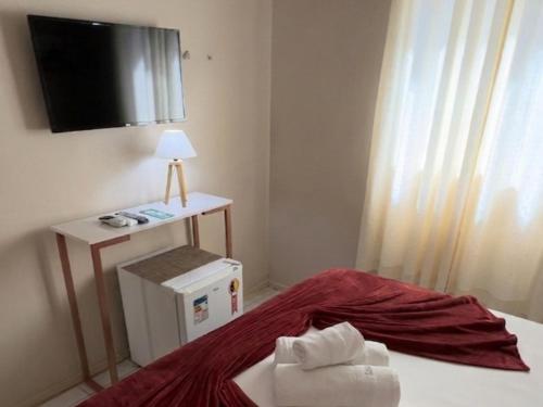 a bedroom with a bed with a television on the wall at Casa do Anjo in Fernando de Noronha