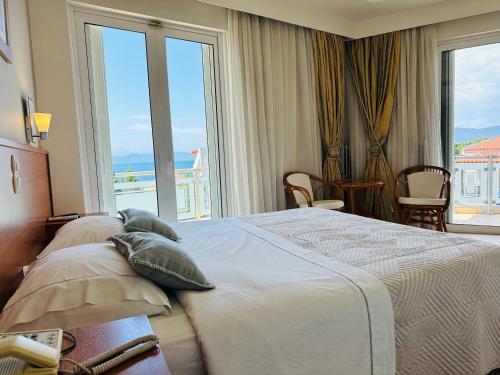 ein Hotelzimmer mit einem Bett und einem großen Fenster in der Unterkunft Souris Hotel in Rovies
