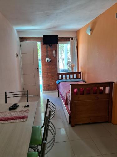 a bedroom with a bed and a desk and a television at Complejo FE LE SA in Las Grutas