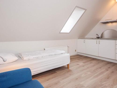 a attic bedroom with a bed and a kitchen at 2 person holiday home in Ringkøbing in Ringkøbing