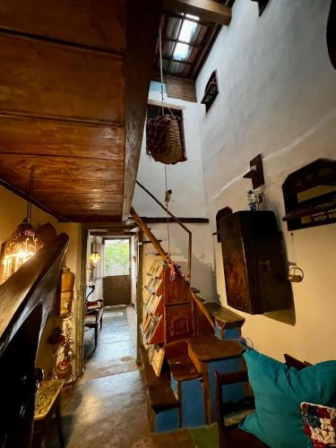 a room with a staircase and a living room at CASA DE RETALHOS Boutique Albergue, casaril histórico, com 5 suítes individuais e cozinha coletiva, no coração da vila de Igatu-Ba, que preserva fortes traços culturais da época do garimpo, venha viver uma experiência única! in Igatu