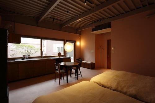 a bedroom with a bed and a table and a window at たゆら in Nara