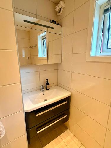 a bathroom with a sink and a mirror at Flott 4-roms leilighet til leie in Trondheim