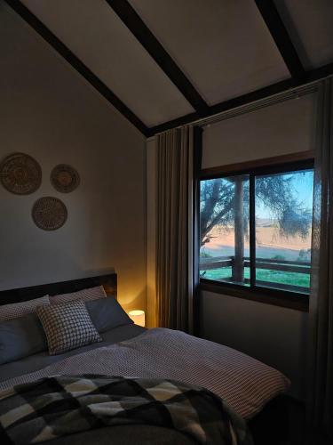 a bedroom with a bed and a large window at 12 Apostles Cottages - Tullarook in Princetown