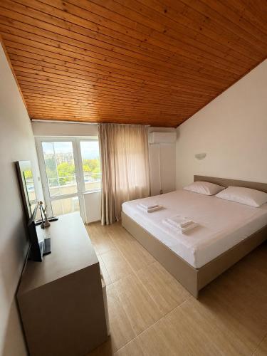 a bedroom with a large bed with a wooden ceiling at Siana House in Ravda