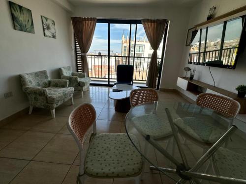 a living room with a glass table and chairs at Lindo Departamento con Terraza Vista al Mar in Pimentel