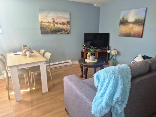 a living room with a couch and a table at Logis des prodiges - Le 775 in Rouyn-Noranda