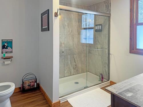 a shower with a glass door in a bathroom at Ultimate Hayward Trailhead Cabin - Base Camp 77 in Hayward