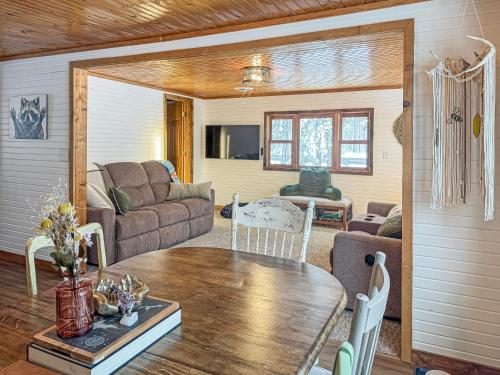 a living room with a table and a couch at Ultimate Hayward Trailhead Cabin - Base Camp 77 in Hayward