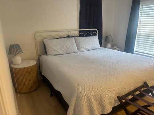 a bedroom with a bed with two lamps and a chair at Seaside Retreat Cottages #1 in Clearwater Beach
