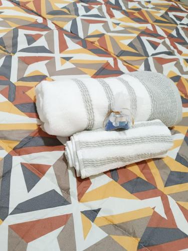two rolled up towels sitting on a patterned bed at Residencia Multifamiliar Sammy in Trujillo