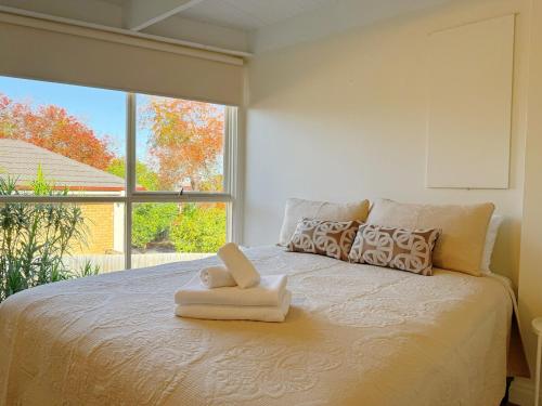a bed with a towel on it with a window at Doncaster Westfiled House 4BD in Doncaster