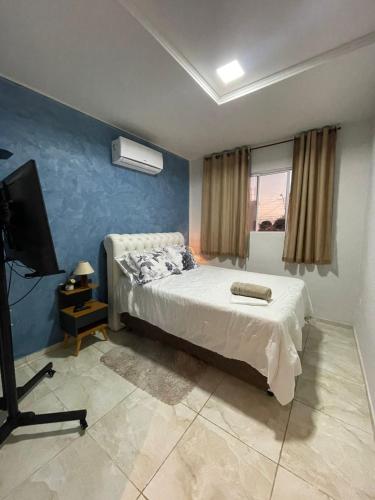 a bedroom with a bed and a flat screen tv at New House Temporada in João Pessoa