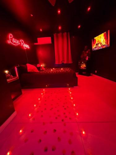 a red room with a bed and lights in it at La nuit éternelle in Amilly