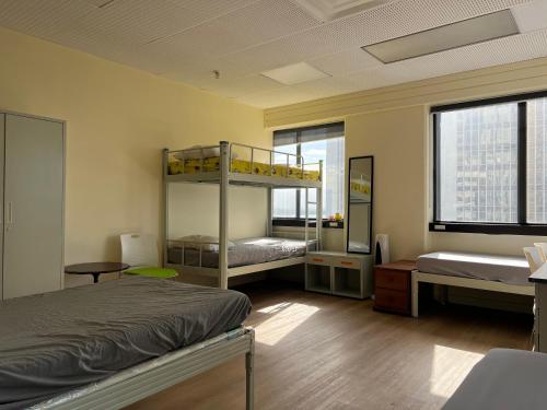 a bedroom with two bunk beds and a window at Garden Hostel in Auckland