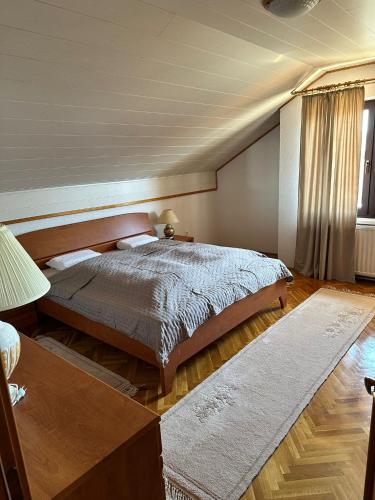 a bedroom with a large bed and a table at Villa Lana in Bihać