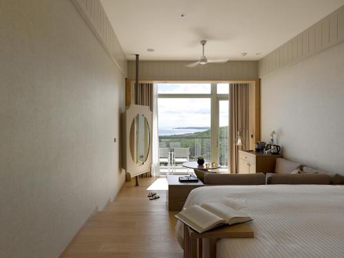 a bedroom with a bed and a living room at Gloria Manor in Kenting