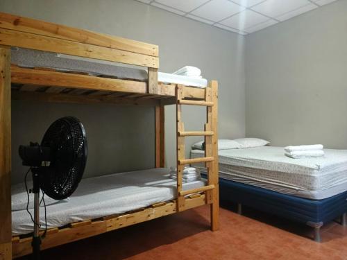 a room with two bunk beds and a fan at VitaHostal in León