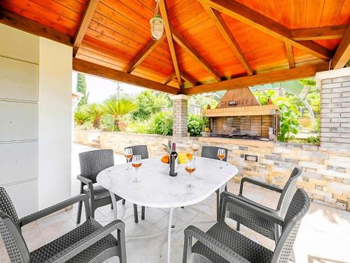 a patio with a table and chairs and a fireplace at Villa Nirvana - Sea View Maisonette in Roda, Offering Tranquility and Comfort on the Enchanting Northern Coast of Corfu in (( Litherés ))