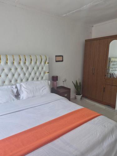 a bedroom with a large bed with an orange blanket at Maroon House in Narok