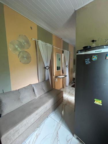a living room with a couch and a refrigerator at Apartamento Reserva Sapiranga in Praia do Forte