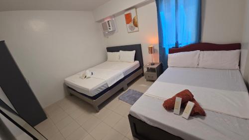 a hotel room with two beds with towels on them at Plumera Mactan Condominium near Airport in Bankal