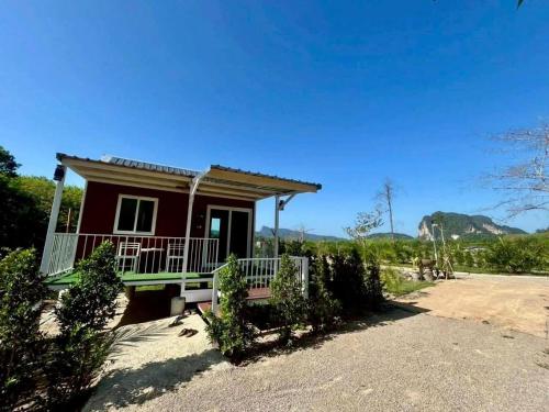 a small red house with a front porch at Nordic Mountain View in Ban Khlong Chi Lat