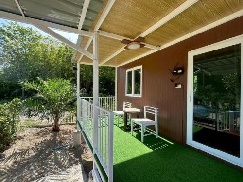 a screened in porch with a table and chairs on it at Nordic Mountain View in Ban Khlong Chi Lat