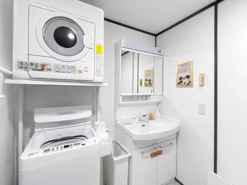 a small white bathroom with a sink and a microwave at 紡ぎの宿 桜 - 民泊 - Tsumugi no Yado SAKURA in Abiko