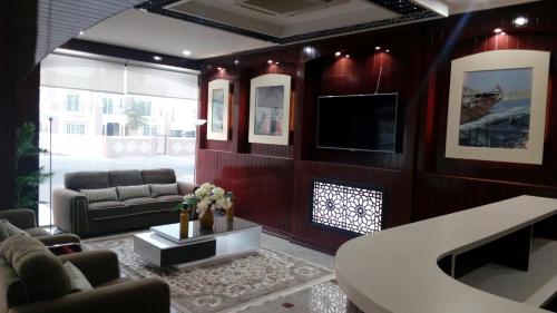 a living room with a couch and a tv at Wanasa Inn Apartments in Mawāliḩ