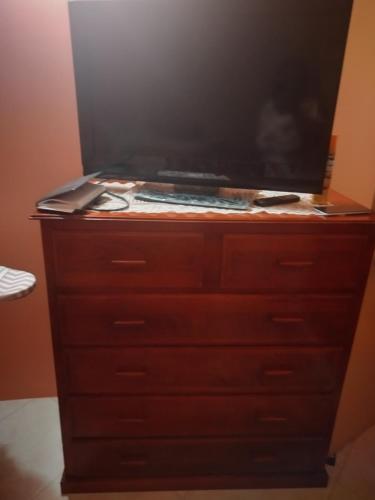 a dresser with a flat screen tv on top of it at Carol Resident in The Grove