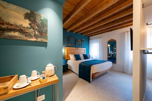a bedroom with a bed and blue walls at Spaccavento Boutique Rooms in Chioggia