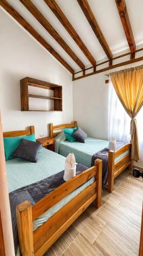 a bedroom with two beds and a window at Boutique La Gloria in Villa de Leyva