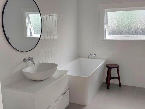 a bathroom with a sink and a tub and a mirror at Inner city Sanctuary in Gisborne