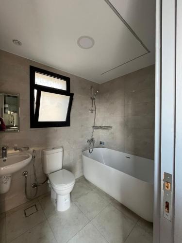 a bathroom with a tub and a toilet and a sink at Modern Rooftop with Stunning View Iconic Tower in Madīnat aţ Ţalāʼi‘