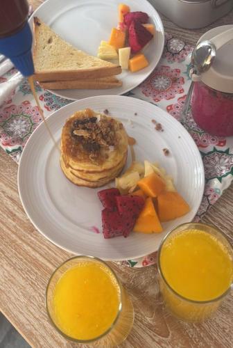 a table with two plates of breakfast food on it at Sandy Beach Villas in Toyapakeh