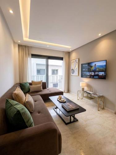 a living room with a couch and a tv at Diyafa Invest in Oulad Akkou